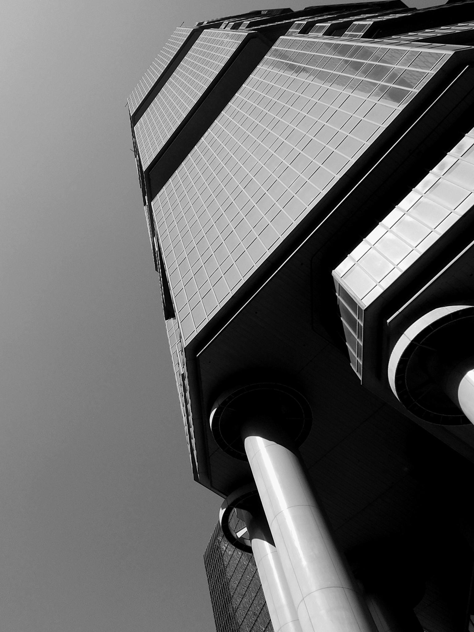 From below of contemporary skyscraper with columns and glass mirrored facade on sunny day in Hong Kong